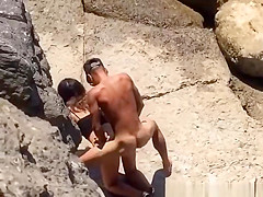 Couple spied in rocky beach having sex