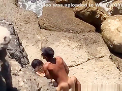Couple spied in rocky beach having sex