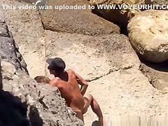Couple spied in rocky beach having sex