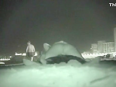 Voyeur films couples at night on a beach