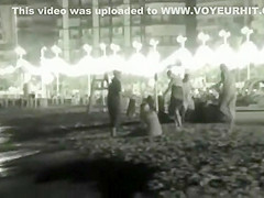 Voyeur films couples at night on a beach