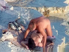 Nude couple fucking at rocky beach