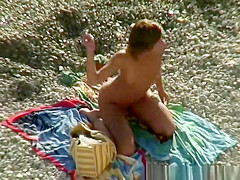 Nude woman rides her man's dick in beach