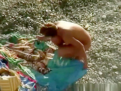 Nude woman rides her man's dick in beach