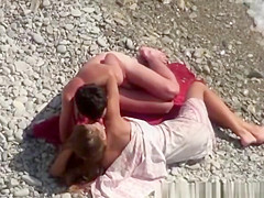 Nudist couple making out in the rocky beach