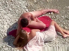 Nudist couple making out in the rocky beach