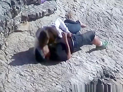 Girl masturbates her guy in the rocks