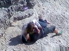 Girl masturbates her guy in the rocks