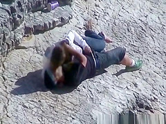 Girl masturbates her guy in the rocks