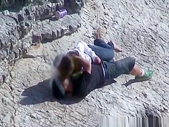 Girl masturbates her guy in the rocks
