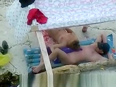 Nudist couple spied on beach.