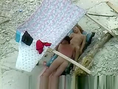 Nudist couple spied on beach.
