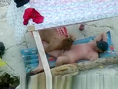 Nudist couple spied on beach.