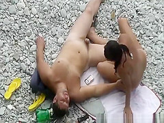 Black hair nudist and her man at beach