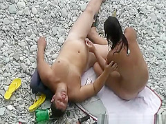 Black hair nudist and her man at beach