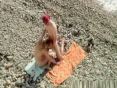 Two nudist couples having sex on the beach
