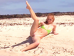 Hot redhead posing in tiny sling bikini on the public beach