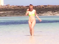 Hot redhead posing in tiny sling bikini on the public beach