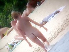 A family spends the day at the beach by sunbathing in the n