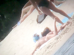 A family spends the day at the beach by sunbathing in the n