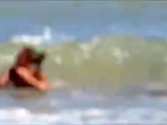 Topless legal age teenager playing at beach in water