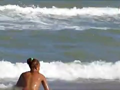Topless legal age teenager playing at beach in water