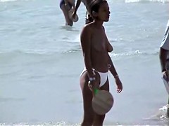 Topless babes getting caught on tape while acting naughty on the public beach