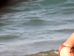 Topless girl playing on the beach and getting voyeured