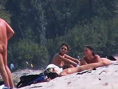 Adults taking sunbaths and relaxing on the nude beach
