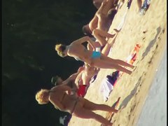 Smooth ass babes on the beach are showing their boobies