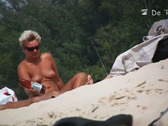 Wonderful babes are sitting on the beach and oiling themselves