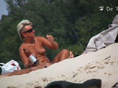 Wonderful babes are sitting on the beach and oiling themselves