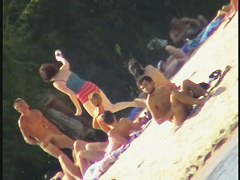 a voyur porno of a sexy blonde chick sitting tanning on a beach