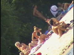 a voyur porno of a sexy blonde chick sitting tanning on a beach