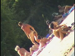 a voyur porno of a sexy blonde chick sitting tanning on a beach