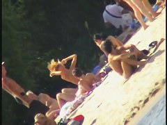 a voyur porno of a sexy blonde chick sitting tanning on a beach
