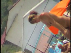 Nudist video at the beach has shy girl playing in the water