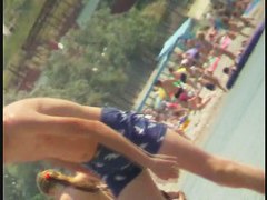 Nudist video at the beach has shy girl playing in the water