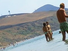 Sexy teeny babes topless on a beach get filmed by a voyeur camera