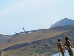 Sexy teeny babes topless on a beach get filmed by a voyeur camera