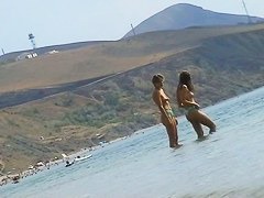 Sexy teeny babes topless on a beach get filmed by a voyeur camera
