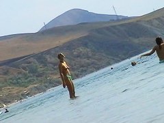 Sexy teeny babes topless on a beach get filmed by a voyeur camera