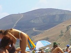 Sexy teeny babes topless on a beach get filmed by a voyeur camera