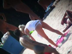 Beach voyeur vid features a hot blonde topless girl.