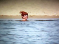 Intriguing, hot redhead in a nude beach video