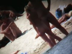 A voyeur beach video of a nude couple standing in the water