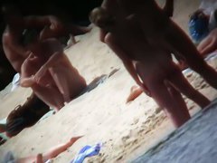 A voyeur beach video of a nude couple standing in the water