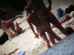 A voyeur beach video of a nude couple standing in the water