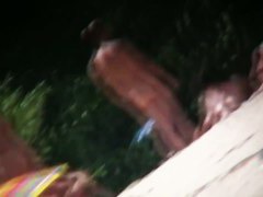 A voyeur beach video of a nude couple standing in the water