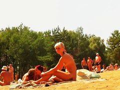 Wives and their husbands sunbathing at the nudist beach